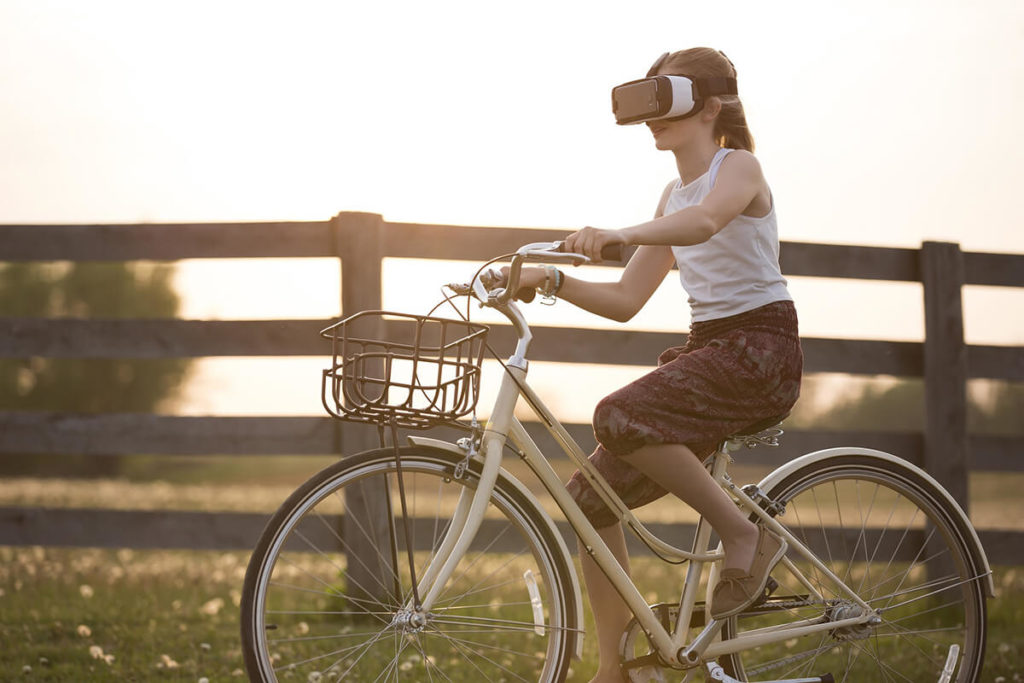 Girl wearing a virtual headset while riding a bike